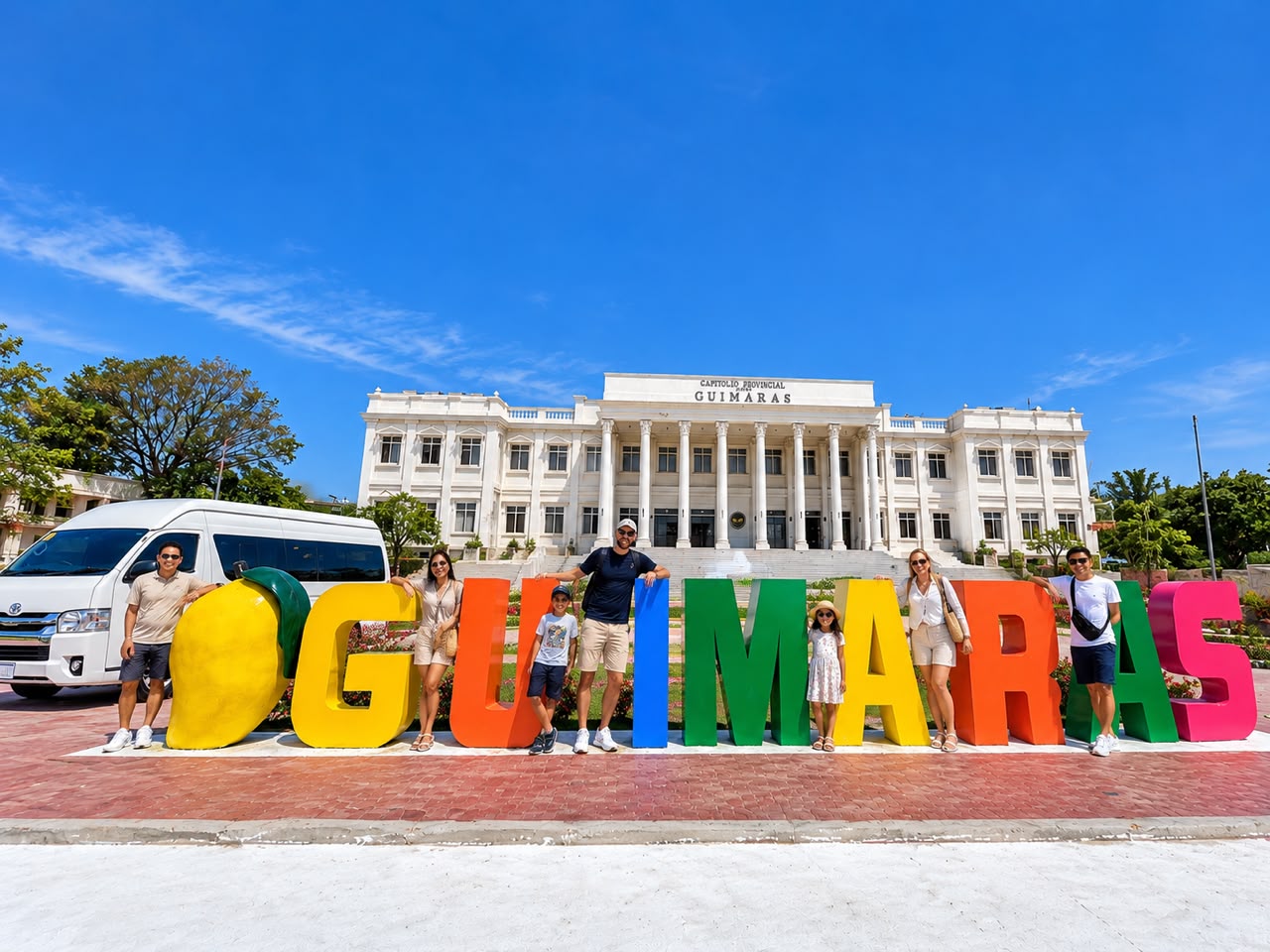 Travellers at the colourful Guimaras sign in front of the provincial capitol, with an ELA's van
